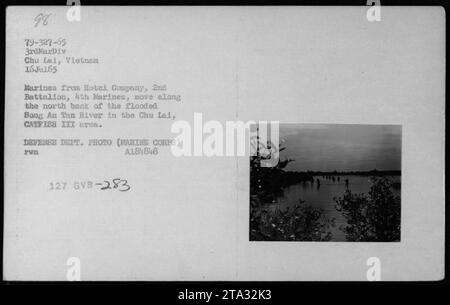 Des Marines de la compagnie hôtelière, 2e bataillon, 4e Marines, effectuent des patrouilles le long de la rivière Song an Tan inondée dans la région de Chu Lai, au Vietnam, le 16 juillet 1965. La photo a été prise lors des opérations CATFISH III par le Département de la Défense (corps des Marines). Banque D'Images