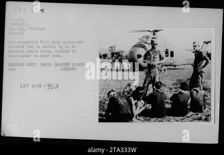 Six prisonniers présumés Viet Cong transportés par hélicoptère vers une zone arrière par les Marines américains lors d'une bataille à Chu Lai, Vietnam, le 21 août 1965. Photographie prise par le Département de la Défense (corps des Marines). Banque D'Images