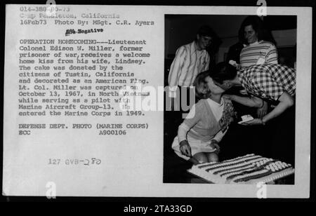 Le lieutenant-colonel Edison W. Miller, un ancien prisonnier de guerre, reçoit un baiser de bienvenue de sa femme Lindsey. Les citoyens de Tustin, Californie, ont fait don d'un gâteau décoré comme un drapeau américain pour célébrer son retour. Le lieutenant-colonel Miller, un pilote du Marine Aircraft Group-13, a été capturé au Nord-Vietnam le 13 octobre 1967. Banque D'Images