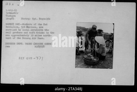 Les Marines AMÉRICAINS du 2e Bataillon, le 3e Marines, achètent des marchandises auprès de détaillants vietnamiens lors d'une journée de marché à Danang, au Vietnam. La photo, prise le 1 août 1965, montre des militaires achetant des produits et des boissons gazeuses à environ 10 miles au nord-ouest de la base aérienne de Danang. (Photographie de 8ZR. Reynolds, US Marine corps) Banque D'Images