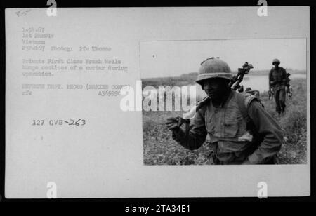 Un soldat du corps des Marines, Frank Wells, transporte des sections d'un mortier lors d'une opération militaire au Vietnam. La photographie a été prise le 23 février 1967 par le soldat de première classe Thomas PFE. L'image capture les efforts dévoués du personnel militaire américain pendant la guerre du Vietnam. » Banque D'Images