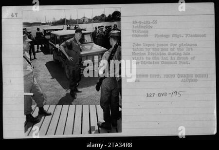 L'acteur John Wayne pose pour des photos devant le poste de commandement de la Division lors de sa visite à Chu Lai le 20 juin 1966. Les photographies ont été prises par les hommes de la 1e Division des Marines. Cette image capture l'interaction de l'acteur avec le personnel militaire pendant la guerre du Vietnam. Banque D'Images