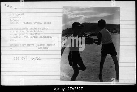 Des enfants vietnamiens jouant dans un village, photographiés le 8 juillet 1966. L'image montre des enfants locaux s'engageant dans le jeu au milieu de la guerre du Vietnam. Cette photo a été prise par GySgt. Kuslo, photographe du 2e Bataillon, 7e Régiment de Marines. La photographie fait partie de la collection du ministère de la Défense - A369225 127 GVB-372. Banque D'Images