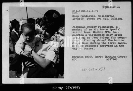 Réfugiés vietnamiens arrivant au camp Pendleton, en Californie, le 29 avril 1975, pendant la guerre du Vietnam. La dirigeante Cherry Flannagan, membre d'une équipe d'action spéciale de l'armée de l'air, peut être vue portant un bébé vietnamien après leur arrivée au Camp Tulega pour un séjour temporaire dans un pavillon. De nombreuses personnalités, dont Claudia Cardinale, Nguyen CAO Ky, Rosemary Clooney et Betty Ford, visité les réfugiés pendant ce temps. La photo a été prise par le caporal Tobiasz pour le Département de la Défense. Banque D'Images