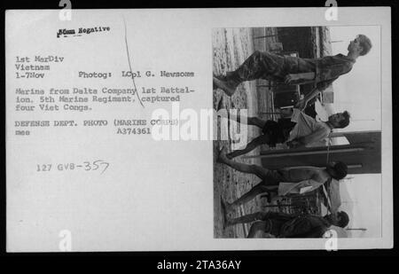 Un Marine américain de la compagnie Delta, 1e bataillon, 5e régiment de Marines a capturé quatre suspects Viet Cong en novembre 1969 pendant la guerre du Vietnam. L'image montre les individus capturés, qui étaient considérés comme des prisonniers, étant détenus et gardés par les Marines. Banque D'Images