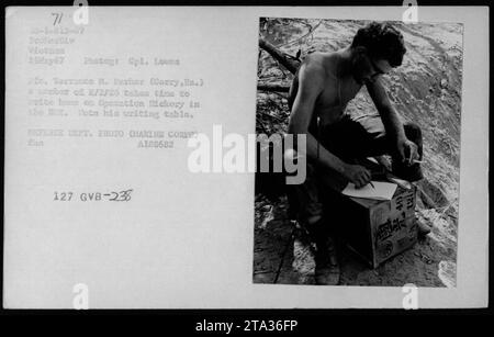 Le Cpl Terrance M. Parker, de Corry, en Pennsylvanie, écrit une lettre à la maison à une table de fortune pendant l'opération Mickory à D12 Hote, au Vietnam, le 26 mai 1967. La photo du Cpl Lowes documente les activités militaires américaines. Banque D'Images