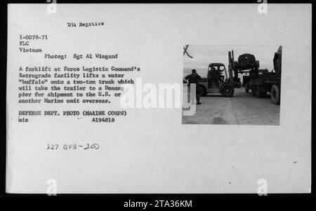 Un chariot élévateur à fourche dans les installations rétrogrades du Force Logistic Command soulève un buffle d'eau sur un camion de deux tonnes, prêt à être expédié à un Danang pler pour le transport vers les États-Unis ou une autre unité marine outre-mer. La photographie est prise par le Sgt Al Wiegand et fait partie de la collection du ministère de la Défense. (Légende : FLC Vietnam - chariot élévateur soulevant l'eau « buffle » sur le camion) Banque D'Images