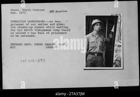 « Un prisonnier de guerre américain sourit et donne le signal en attendant que sa garde de l'armée nord-vietnamienne décharge un bus rempli de prisonniers à libérer, lors de l'opération Homecoming à Hanoi, au Nord-Vietnam, en février 1973. DEPT. DÉFENSE PHOTO (MARINE CORPS) ECC A900055 127 GVB -293 WIDE 63-33-12.' Banque D'Images