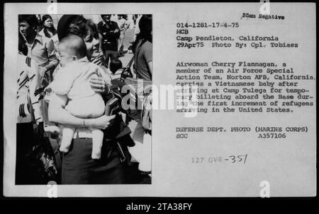 L'aviatrice Cherry Flannagan, membre d'une équipe d'action spéciale de l'Armée de l'Air, porte un bébé vietnamien au Camp Pendleton, Californie, le 29 avril 1975. Le bébé est l'un des premiers réfugiés arrivant aux États-Unis pendant la guerre du Vietnam. Photo prise par le caporal Tobiasz.' Banque D'Images