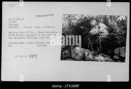 Marines de 'l' Co., troisième bataillon, cinquième régiment de Marines, effectuant une patrouille pendant l'opération Hastings près de Dong Ha. La photographie montre les soldats en mouvement, naviguant sur le terrain accidenté de la guerre du Vietnam. Cette image a été prise le 19 juillet 1966 et fait partie des documents officiels du Département de la Défense des États-Unis. Banque D'Images