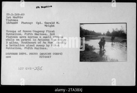 Des troupes de la compagnie Bravo, du premier bataillon, du 5e régiment de Marines, du 3e peloton sont vues traverser un petit ruisseau lors d'une patrouille dans le territoire de l'Arizona, situé à 3 miles au sud-ouest d'an Hoa. Cette image a été capturée le 18 juin 1969, lors d'un balayage de la taille d'un bataillon mené par le premier bataillon, 5e Marines. Banque D'Images