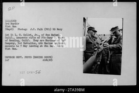 US Marines 1st Lt L.G. collet Jr. De San Rafael, Californie, examine le fusil de pré Gary G. Hayes de Reading, Californie. La photo a été prise le 7 mai 1965, alors qu'ils étaient en route pour un atterrissage à Chu Lai, au Sud Vietnam. Cette image fait partie de la collection de photographies de la guerre du Vietnam du Département de la Défense des États-Unis. Banque D'Images