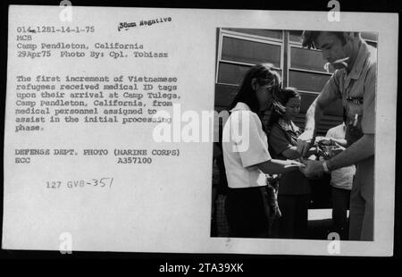 Le premier lot de réfugiés vietnamiens arrivant au Camp Pendleton, en Californie, le 29 avril 1975, reçoit des étiquettes d'identification médicale du personnel médical au cours de la phase initiale de traitement. L'image montre Claudia Cardinale, Nguyen CAO Ky, Rosemary Clooney et Betty Ford rendant visite aux réfugiés. Photographie du Cpl Tobiasz, gracieuseté du Département de la Défense. Banque D'Images