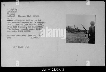 Un hélicoptère UH-1E atterrit pour déposer des journalistes civils lors de l'opération BLUE MARLIN le 10 novembre 1965. Le sergent Bob L. Johnson de la compagnie de golf, 2e bataillon, 7e Marines, monte la garde. Cette photographie a été prise par le SSgt. Brown de la 3e Division Marine au Vietnam. Photo du ministère de la Défense (corps des Marines). Banque D'Images