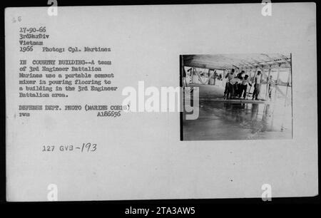 Les Marines du 3e bataillon du génie au Vietnam en 1966 utilisent un mélangeur de ciment portable pour verser le sol dans un bâtiment situé dans la zone du bataillon. L'image capture les activités de construction entreprises par les ingénieurs pendant la guerre. Banque D'Images