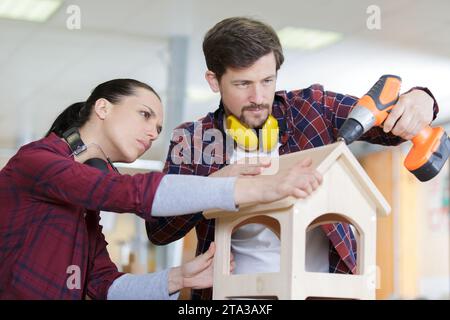 menuisier construisant un nichoir en bois avec sa petite amie Banque D'Images