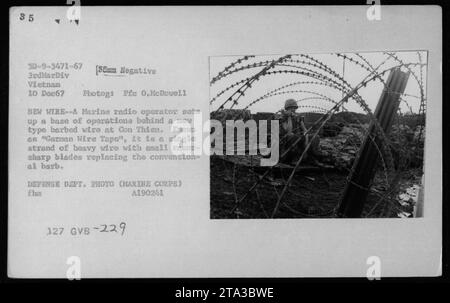 Le 10 décembre 1967, un opérateur radio de la Marine installe une base derrière German Wire Tape, un fil lourd simple avec des lames tranchantes, à Con Thien pendant la guerre du Vietnam. Banque D'Images