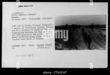 Le personnel DE L'ARMÉE DE LA RÉPUBLIQUE DU VIETNAM (ARVN), ainsi que les Marines américains du programme d'action combinée, sont vus patrouiller dans les dunes de sable près du village de Quang Xuyen. La photographie a été prise le 28 mars 1970, au Camp Jay K. Books, au Vietnam, par le sergent H.M. Smith. Il montre un effort conjoint entre les Forces populaires vietnamiennes et les Marines du 3e régiment de Marines et du 3e bataillon. Banque D'Images