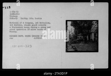 Fusiliers de la compagnie X, 3e bataillon, 3e Marines, en garde devant une maison vietnamienne lors d'une opération de balayage et de dégagement à 18 miles au sud de Danang le 24 novembre 1965. Ils font partie de la 3e Division Marine au Vietnam. La photo est prise par le PFC Durbin et provient du Département de la Défense. Banque D'Images