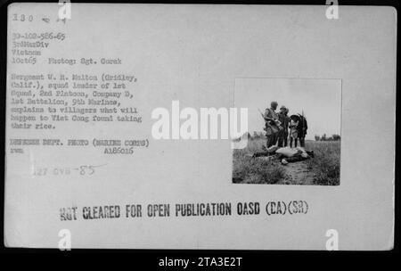 Sergent W.R. Melton, chef d'escouade de la 1e escouade, 2e peloton, compagnie D, 1e Bataillon, 9e Marines, explique aux villageois les conséquences pour tout Viet Cong capturé prenant leur riz le 1 octobre 1965. Cette photographie a été prise pendant les combats au Vietnam par le sergent Gorak et fait partie de la collection officielle de photos du corps des Marines des États-Unis. [Source : Département de la Défense des États-Unis, photo officielle du corps des Marines] Banque D'Images