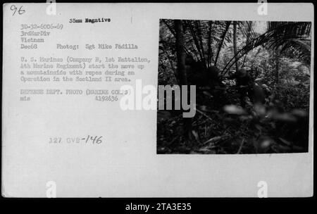 Des Marines américains de la compagnie B, 1e bataillon, 4e régiment de Marines, sont montrés commencer leur ascension vers le haut d'une montagne lors de l'opération Scotland II en décembre 1968. L'image capture les Marines en utilisant des cordes pour naviguer sur le terrain difficile. Cette photographie a été prise par le sergent Mike Padilla et fait partie d'une série documentant les activités militaires américaines pendant la guerre du Vietnam. (DEPT. DÉFENSE PHOTO, MARINE CORPS, MIS 41392636) Banque D'Images