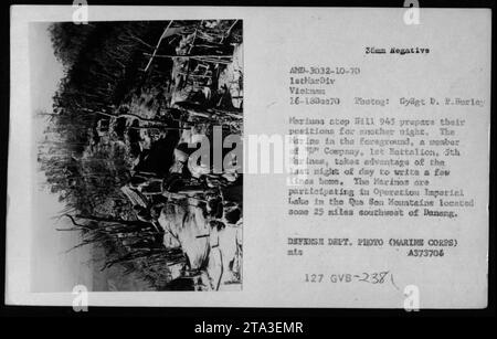 Le 16 décembre 1970, les membres de la compagnie P, 1er bataillon, 5e Marines, préparent des positions sur la B111 945 dans les montagnes que son lors de l'opération Imperial Lake, au Vietnam. Un Marine écrit une lettre chez lui au crépuscule. La photographie de Gysgt D.P. Hurley capture la vie quotidienne et la correspondance postale sur le terrain. Banque D'Images