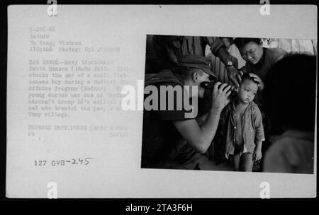 Le lieutenant David Henson (Idaho Falls, Idaho) vérifie l'oreille d'un petit garçon vietnamien lors d'un programme médical d'affaires civiles (MEDCAP) dans le village de Thuy, Da Nang, Vietnam, le 11 octobre 1966. Henson, qui fait partie du personnel médical du groupe d'avions 16, a fourni des soins aux villageois locaux. Cette photo intense a été prise par le caporal Johnson. Banque D'Images