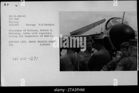 Le secrétaire à la Défense, Robert S. McNamara, inspecte le Marine Aircraft Group 11 (MAG-11) lors de sa visite au Vietnam en juillet 1967. La photographie le montre en train de discuter avec des journalistes, accompagné d'officiers et de fonctionnaires, dont le vice-président Hubert Humphrey, le général William Westmoreland et le sénateur Harry F. Byrd. Banque D'Images