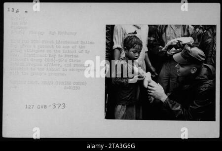 Une photographie montrant le lieutenant Dallas Bay, un pilote, offrant un cadeau à un jeune villageois sur l'île de Ly pendant la guerre du Vietnam. Le Lieutenant Bay est un officier du Programme d'action civique du Marine Aerofs Group (G)-36. L'image a été prise le 9 juin 1967 et fait partie de la vie civile vietnamienne pendant la guerre. Banque D'Images