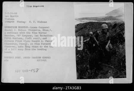 Le caporal Daniel J. Nelson (arrière gauche) et le soldat de première classe Emmett A. Ferra font de longs pas en haut d'une colline loin de la plage de débarquement lors de l'opération Houston le 14 mars 1968. Nelson sert de radioman avec la section de mortier de 81mm tandis que Ferra est un observateur avant de 81um. Photo prise par W. F. Dickman, ministère de la Défense. Banque D'Images