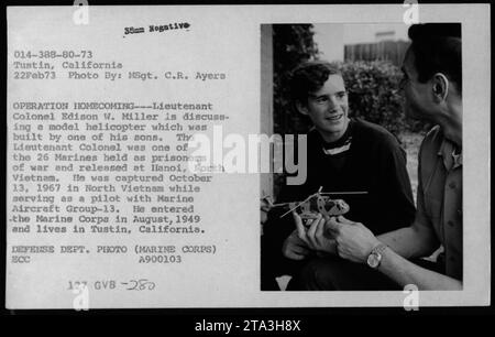 Le lieutenant-colonel Edison W. Miller, un ancien prisonnier de guerre, discute d'une maquette d'hélicoptère construite par l'un de ses fils lors de l'opération Homecoming le 22 février 1973. Il faisait partie des 26 Marines libérés à Hanoi, au Nord-Vietnam. Capturé en octobre 1967 alors qu'il servait comme pilote, le lieutenant-colonel Miller entre dans le corps des Marines en 1949 et réside à Tustin, en Californie. La photographie a été prise par le MSgt. R. Ayers, crédité au Département de la Défense (corps des Marines). Banque D'Images