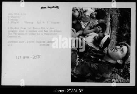 Un Marine du 1e Bataillon de Recon observe une femme vietnamienne soupçonnée d'être communiste et ses enfants. Cette image a été prise le 1 mai 1970, pendant la guerre du Vietnam. La photographie, étiquetée AMD-1293-5-70, a été prise par le caporal W. P. Barger. Banque D'Images