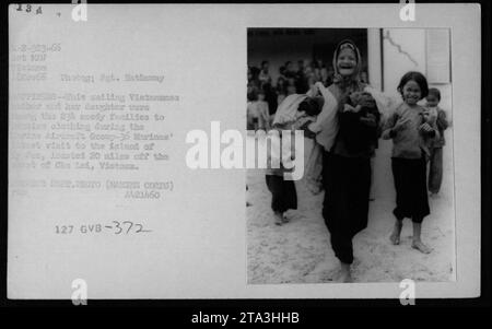 Une photographie prise le 18 novembre 1966 montre une mère vietnamienne et sa fille parmi 234 familles recevant des vêtements lors de la visite du Brine Airdraft Group-36 Marines du corps des Marines sur l'île de son. L'île est située à 20 miles au large de la côte de Chu Lai, Vietnam. Banque D'Images