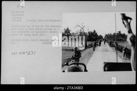 Les membres de la compagnie H, 3e Bataillon, 7e Marines se déplacent vers un nouvel objectif lors de l'opération DeSoto, au sud de la ville de Quang Ngel. Prise le 22 février 1967, cette photographie montre des officiers et des fonctionnaires, dont Hubert Humphrey, le général William Westmoreland et le sénateur Harry F. Byrd, observant les activités militaires. Photographe : Cpl. K.E. Licenseto. Banque D'Images