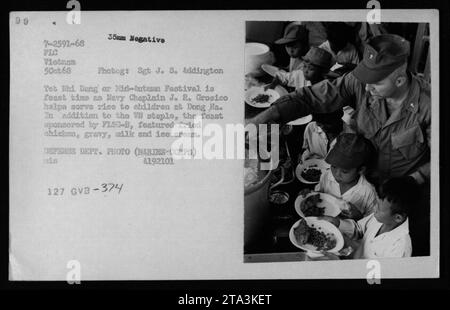 La vie civile au Vietnam - 5 octobre 1968 : l'aumônier de la Marine J. R. Grosico aide à servir du riz aux enfants pendant le Tet Nhi Dang ou Festival de la mi-automne à Dong Ha. Le festin, parrainé par FLSG-B, comprenait du poulet frit, de la sauce, du lait, et de la crème glacée. Photo du Sgt J. S. Addington, Département de la Défense. Banque D'Images