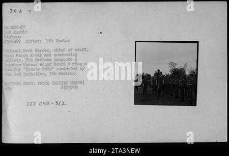 Le colonel Fred Haynes, chef d'état-major et commandant du 5th Marines, inspecte une Garde d'honneur des Forces populaires au cours d'une «foire du comté» de deux jours menée par le 1st Battalion, 5th Marines de l'ARVN (Armée de la République du Vietnam) - 1967. Cette photographie a été prise le 23 janvier 1967 par le photographe Pre porter. Banque D'Images