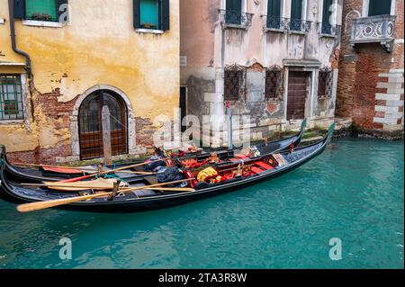 Venise, Italie- 23 février 2023 : deux gondoles amarrées sur un canal à Venise. Banque D'Images