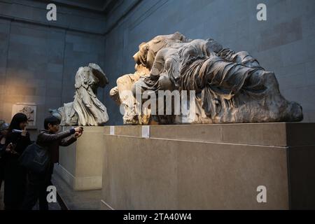 Londres, Royaume-Uni. 28 novembre 2023. Les visiteurs voient des marbres d'Elgin, également connus sous le nom de marbres du Parthénon, au British Museum de Londres, à la suite d'une querelle diplomatique entre le Royaume-Uni et la Grèce. Le Premier ministre grec Kyriakos Mitsotakis devait rencontrer le Premier ministre britannique Rishi Sunak, a annulé une réunion de grande envergure prévue avec son homologue grec Kyriakos Mitsotakis sur une ligne diplomatique sur les marbres du Parthénon. Les marbres sont une collection de sculptures grecques antiques de l'Acropole à Athènes et ont été retirés du Parthénon au début du 19e siècle par Thomas Bruce, le 7e comte d'Elgin Banque D'Images