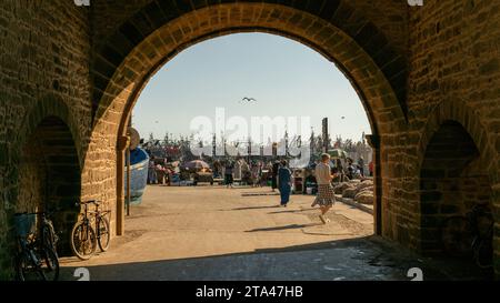 Essaouira, Maroc - 16 septembre 2022 : Port d'Essaouira avec touristes et bateaux de pêcheurs. Les bateaux de pêche bordent le port, apportant le catc de la journée Banque D'Images