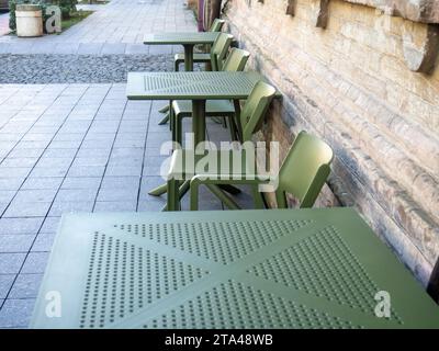 Des tables en plastique vides dans un café. Chaises vertes et tables à l'extérieur. Le concept d'absence de clients. Pas la saison pour les visiteurs. Banque D'Images