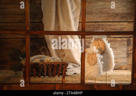 Manger avec mannequin de bébé et de mouton sur fond en bois. Concept de l'histoire de Noël Banque D'Images