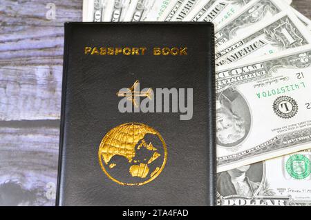 Livre de passeport noir avec un avion et la terre du globe sur sa couverture, concept de voyage et de tourisme, livre de passeport universel, américain USD États-Unis de Banque D'Images