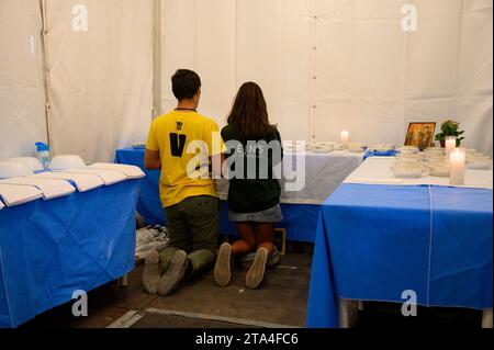 Un garçon et une fille priant en adoration devant l'Eucharistie pour être distribués le lendemain à la Sainte Messe. Veillée avec les jeunes au Parque Tejo. Banque D'Images