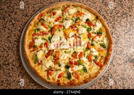 Pizza blanche avec tomates et épinards Banque D'Images