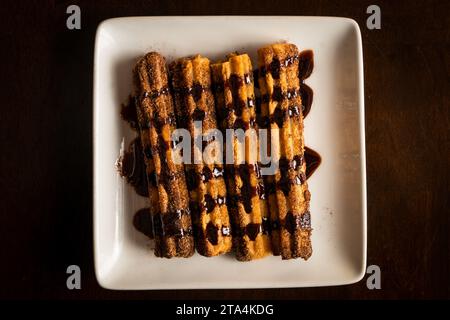 Churros dans une sauce au chocolat Banque D'Images