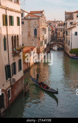 Gondole emblématique planant à travers Serene Venice Canal - scène classique italienne de la voie navigable Banque D'Images