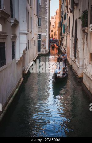 Promenade tranquille en gondole à travers l'étroit canal de Venise avec des bâtiments historiques Banque D'Images