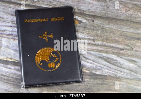 Livre de passeport noir avec un avion et la terre du globe sur sa couverture, concept de voyage et de tourisme, livre de passeport universel pour protéger le passeport Identifiant Banque D'Images