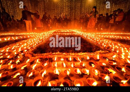 Varanasi, Inde. 27 novembre 2023. Les dévots allument des lampes à huile en terre à l'occasion de Dev Deepavali. Dev Deepavali, également connu sous le nom de Diwali des Dieux, est un festival célébré sur Karthik Purnima, qui tombe 15 jours après Diwali. Dev Deepavali est le plus grand festival de lumière de l'Inde où les dévots décorent la rive du Gange avec des millions de lampes dans le cadre du festival. Crédit : SOPA Images Limited/Alamy Live News Banque D'Images