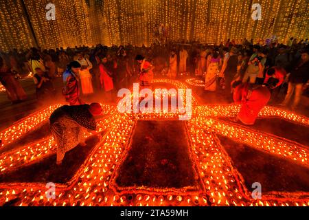 Varanasi, Inde. 27 novembre 2023. Les dévots allument des lampes à huile en terre à l'occasion de Dev Deepavali. Dev Deepavali, également connu sous le nom de Diwali des Dieux, est un festival célébré sur Karthik Purnima, qui tombe 15 jours après Diwali. Dev Deepavali est le plus grand festival de lumière de l'Inde où les dévots décorent la rive du Gange avec des millions de lampes dans le cadre du festival. (Photo Avishek Das/SOPA Images/Sipa USA) crédit : SIPA USA/Alamy Live News Banque D'Images